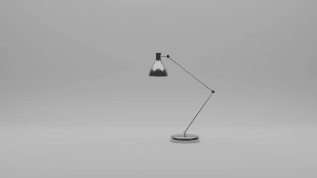 a desk lamp made of shiny metal stands on the white backdrop